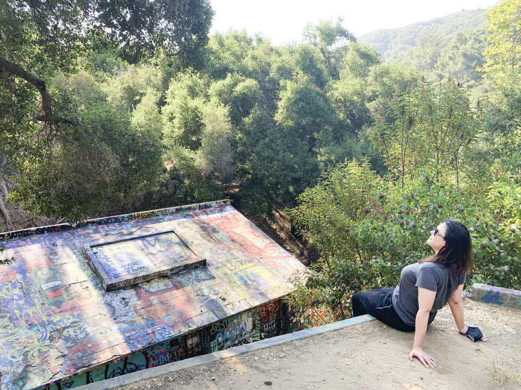 a woman sits on the roof of an abandoned structure at Murphy Ranch