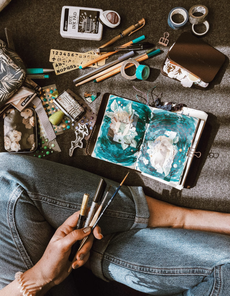 a woman sits on the floor with scrapbooking supplies. gift ideas for artists and creators.