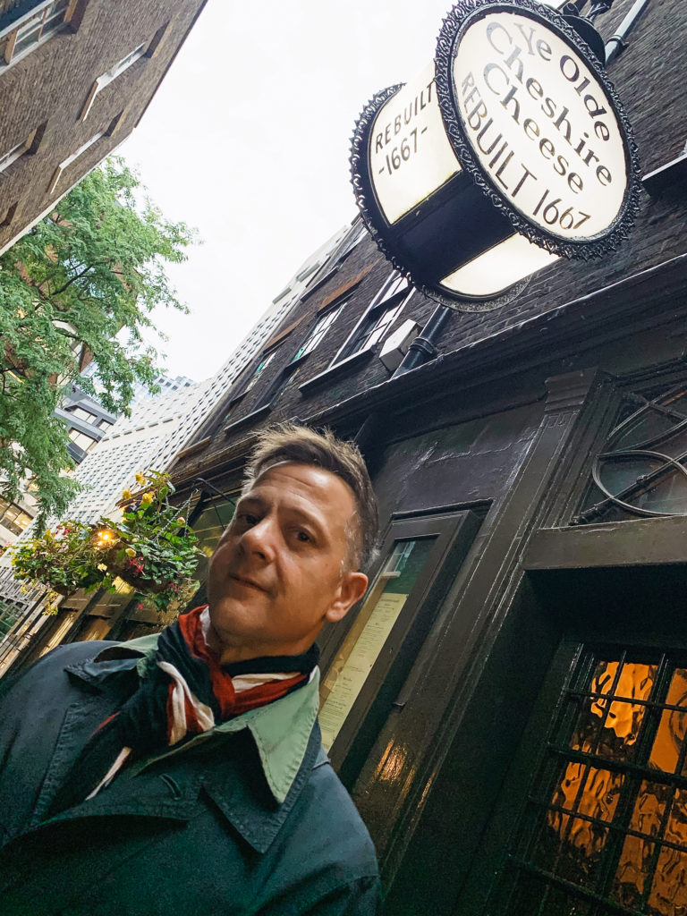 a man stands in front of the English pub Ye Olde Cheshire Cheese