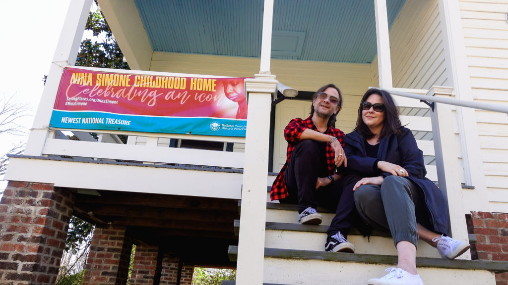 two people sitting on the front steps of Nina Simone's childhood home in Tryon, North Carolina