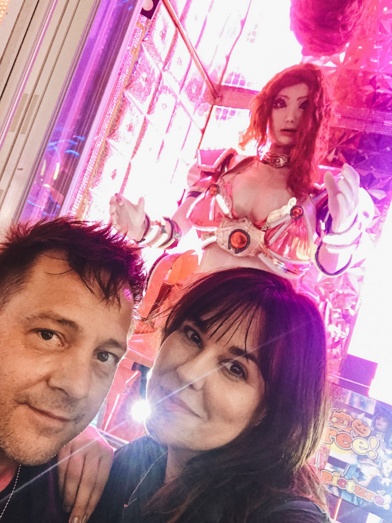 Stephen and Andie pose in front of a robot outside of the Robot Restaurant in Tokyo, Japan