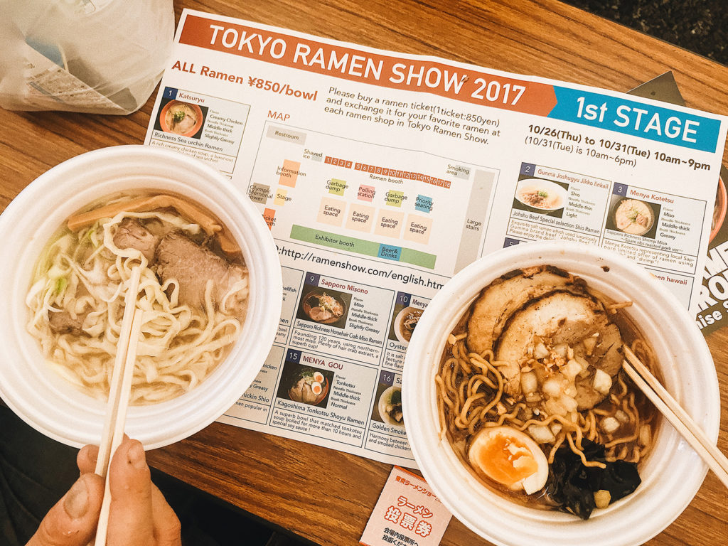 bowls of ramen on a table with chop sticks and a program for the Ramen Festival