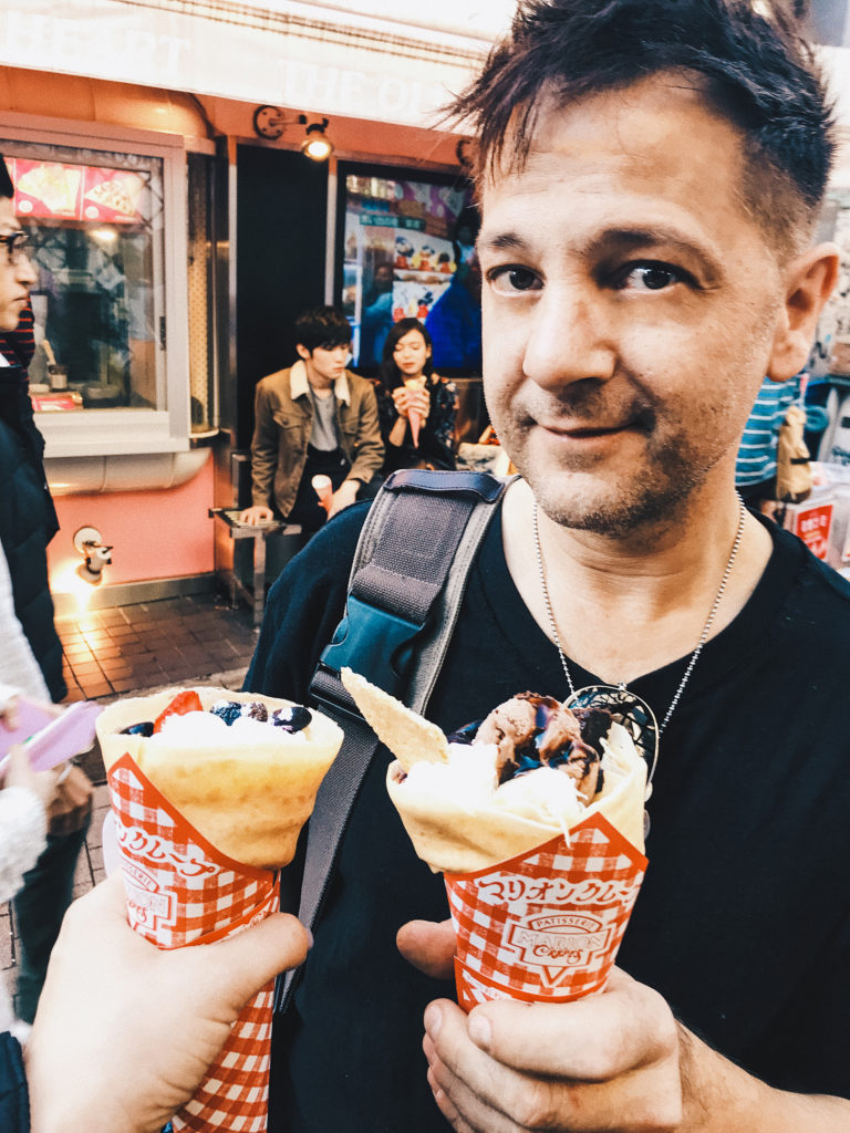 a man holding stuffed crepes in Harajuku
