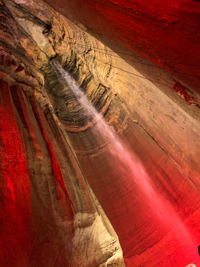 an underground waterfall bathed in red light