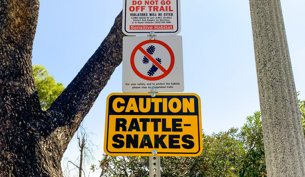 hiking path signs warning hikers about rattlesnakes