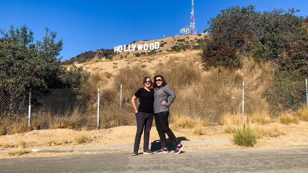 a couple posing in front of the Hollywood sign
