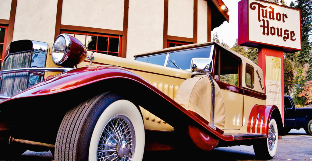 a mobster-style antique car parked in front of Tudor House