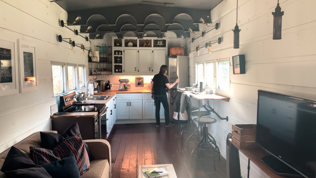 the living room and kitchen inside a train car airbnb