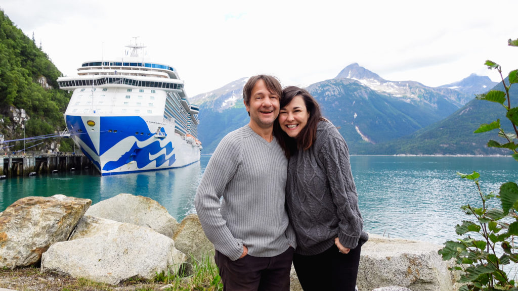 Stephen & Andie pose in Alaska in front of their cruise ship Princess Cruises Majestic Princess