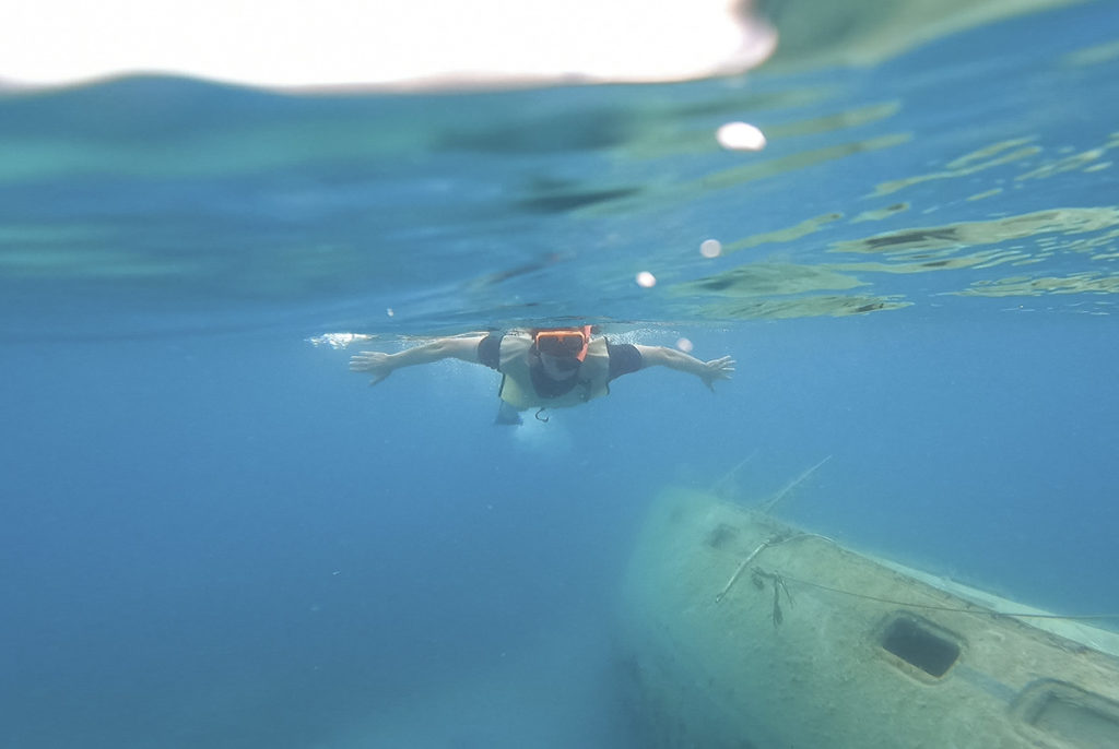 man swimming above sunken ship during snorkeling excursion in Virgin Islands National Park near St. John, U.S. Virgin Islands