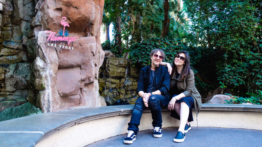 Man and woman posing in front of The Flamingo Hotel & Casino in Las Vegas