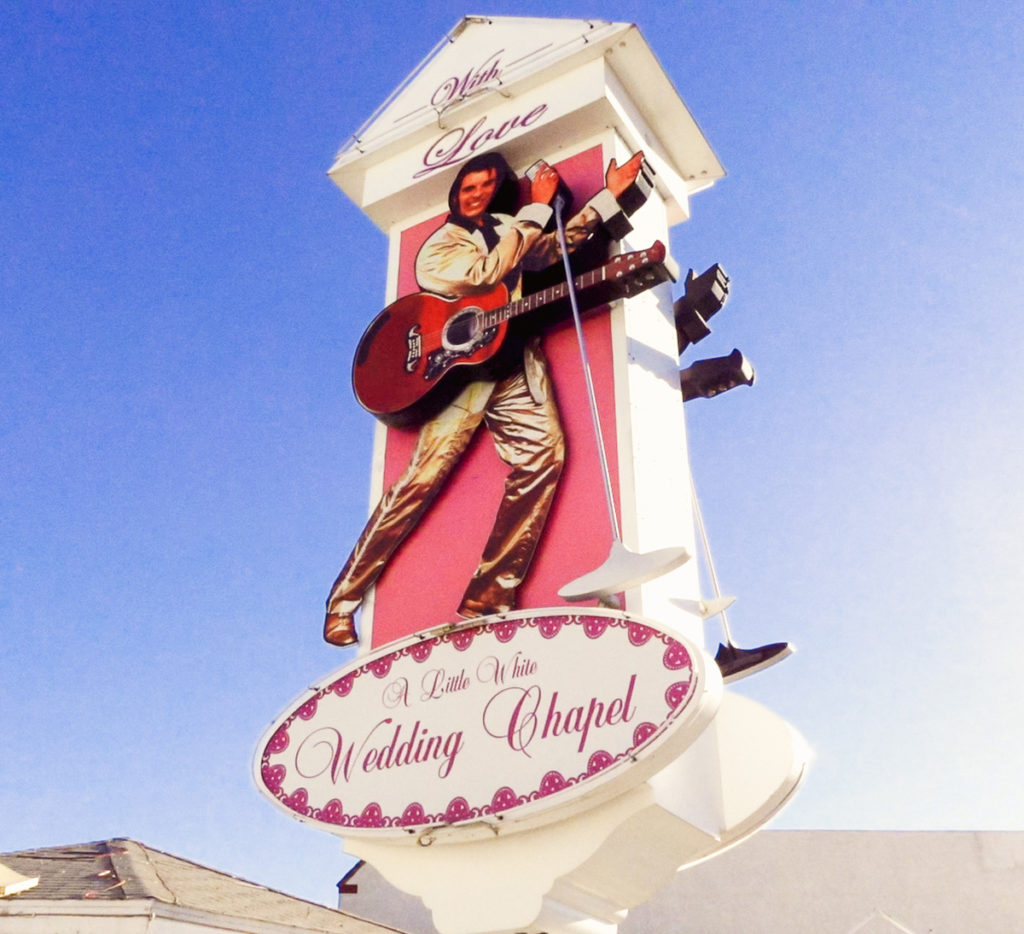 The main sign of A Little White Wedding Chapel in Las Vegas which has the likeness of Elvis Presley dancing with a guitar and microphone