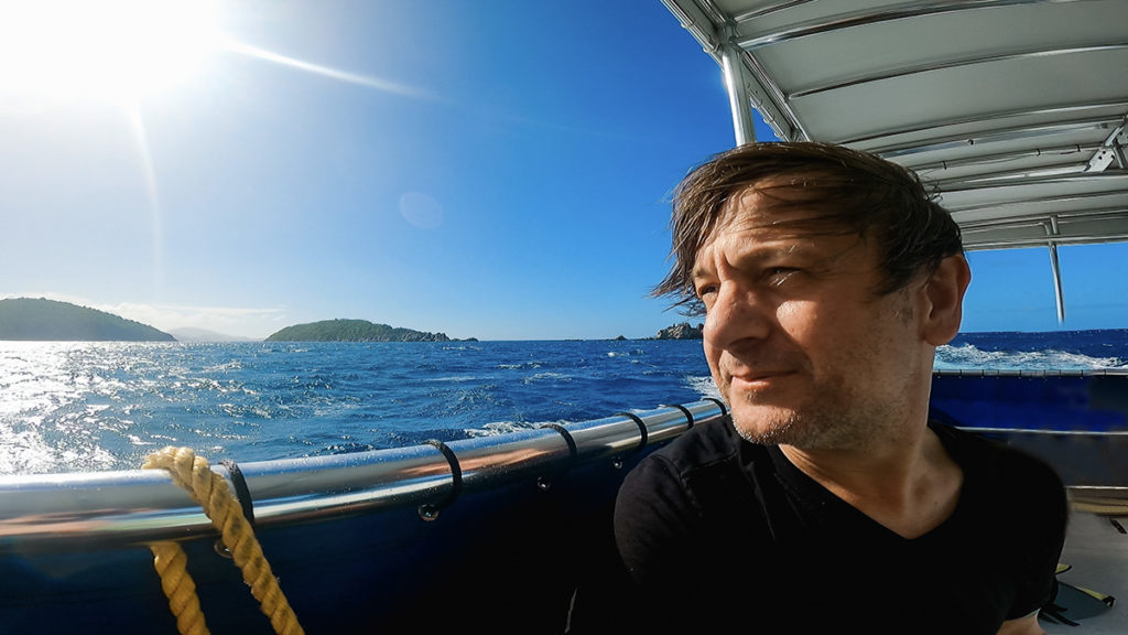 a man looks out over the water from inside a small tour boat in St. Thomas.