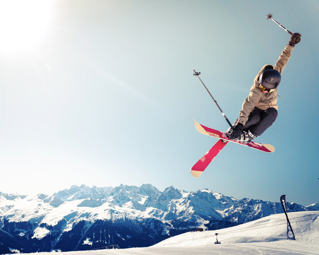 a skier performing a jump on a snowy mountain slope