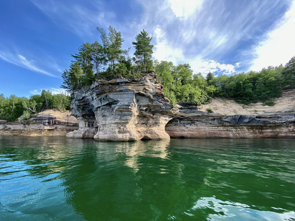 a cliff and trees landscape along a shoreline