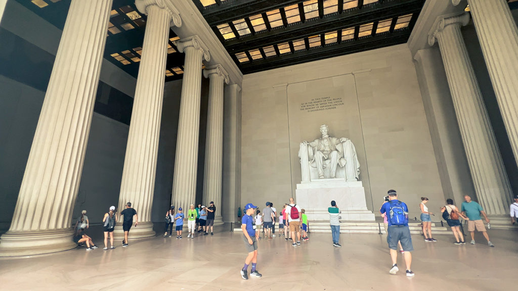 the Lincoln Memorial with several tourists in the foreground and closer to it. - Washington, D.C.