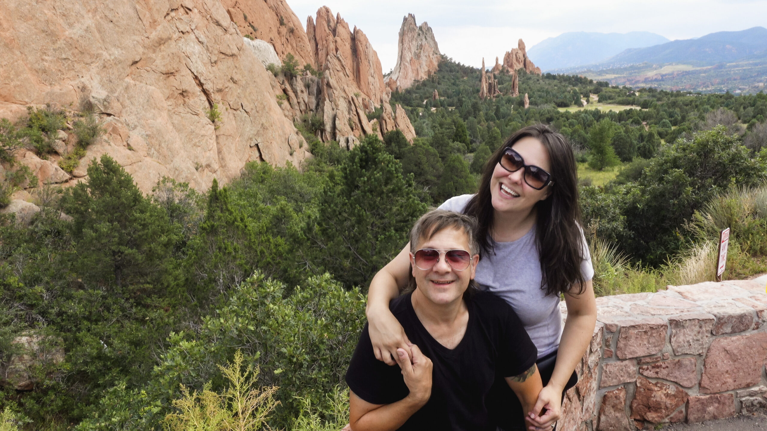 a white couple poses in front of rock formations at Colorado Springs' Garden of the Gods.